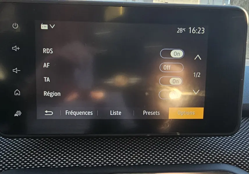 Écran tactile central de la Dacia Sandero III 2022 affichant les options radio avec tableau de bord noir texturé.