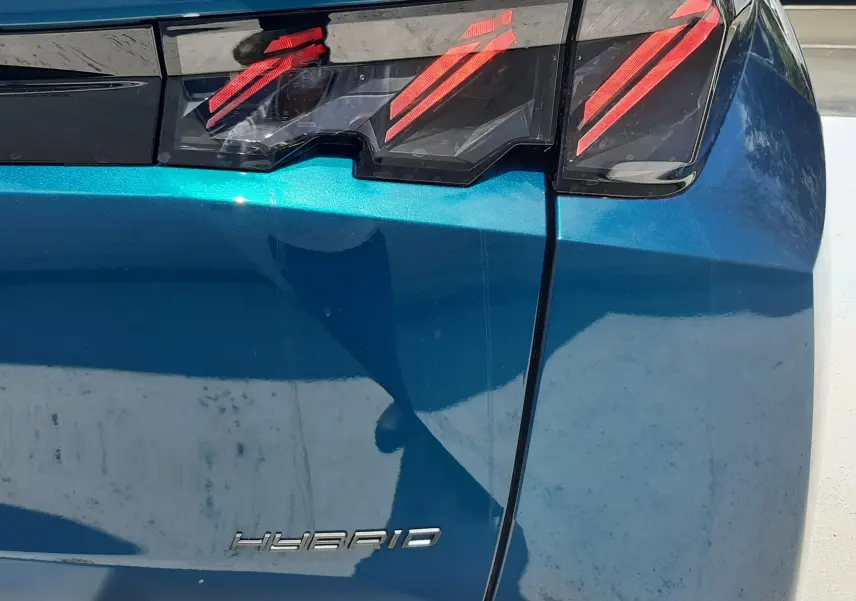 Gros plan sur le feu arrière droit bleu obsession du Peugeot 3008 Hybrid 145ch GT avec logo Hybrid visible.