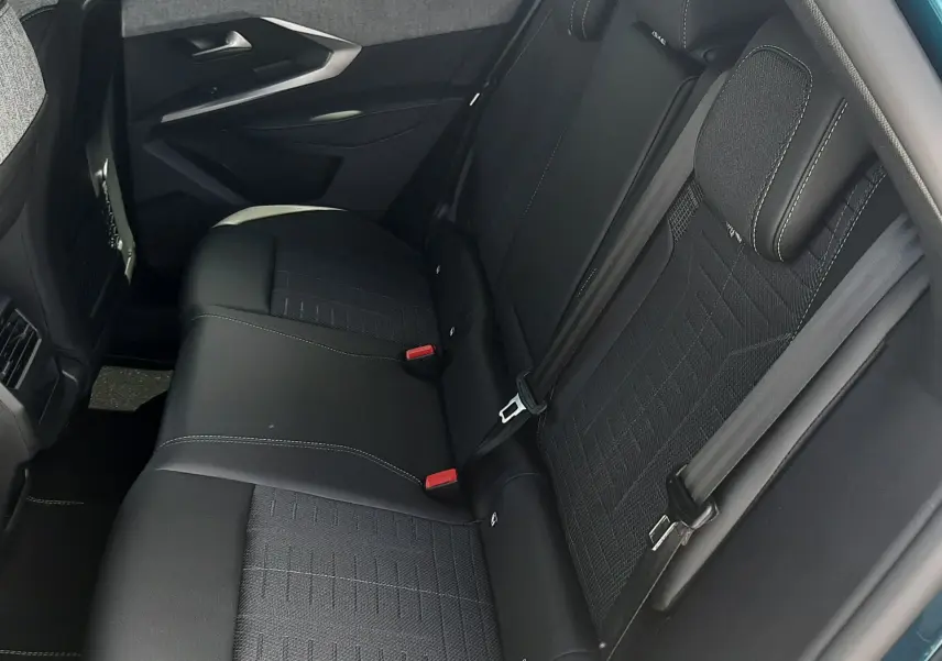 Vue intérieure côté droit des sièges arrière noirs du Peugeot 3008 1.2 Hybrid 145ch GT, avec porte ouverte bleu Obsession.