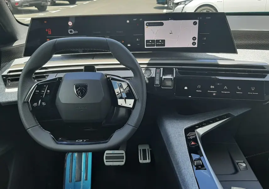 Vue intérieure du tableau de bord et volant du Peugeot 3008 1.2 Hybrid GT, avec écran numérique large et finitions modernes.