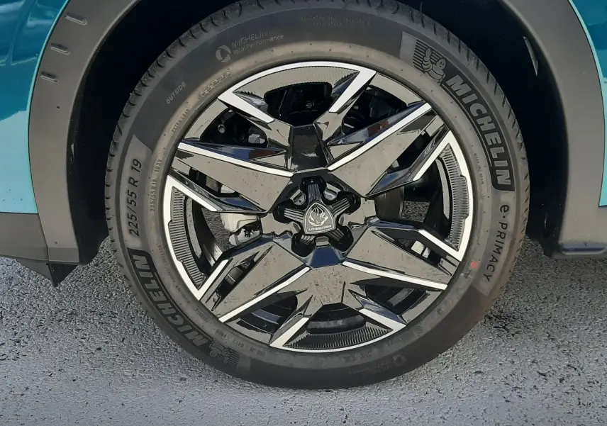Gros plan sur la roue avant droite du Peugeot 3008 1.2 Hybrid 145ch GT bleu obsession avec jante alliage noire et argent.