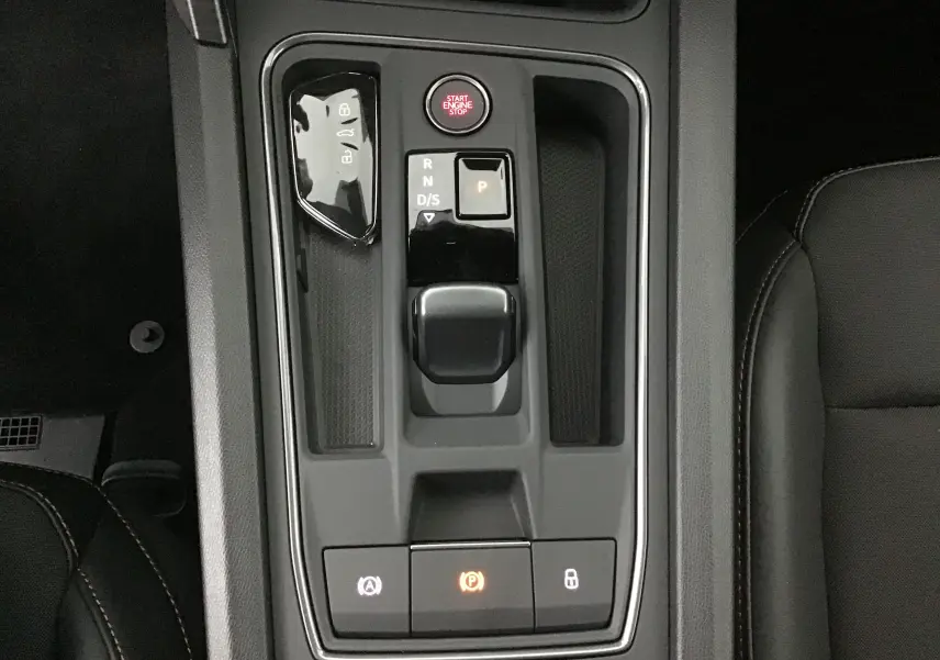 Vue plongeante sur la console centrale noire du CUPRA Leon 2023, avec sélecteur de boîte automatique et bouton start/stop.