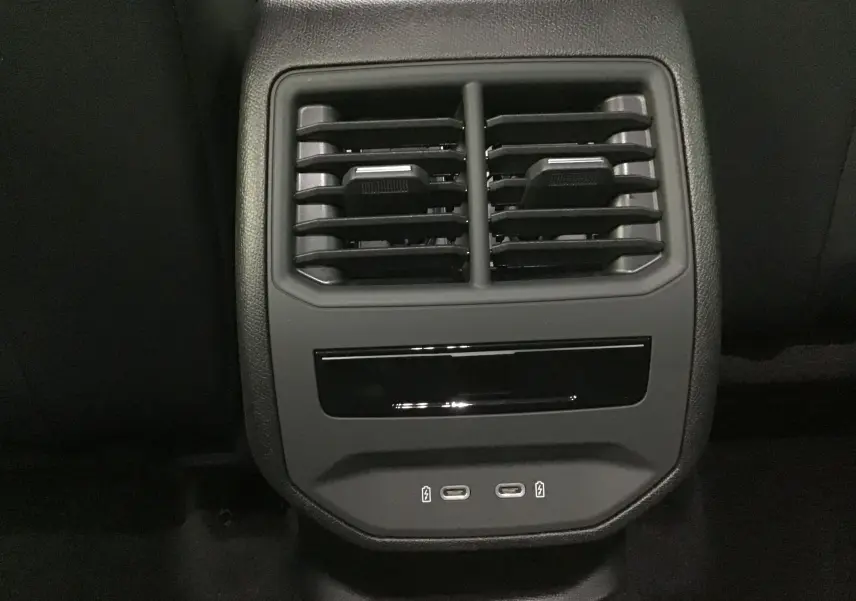 Gros plan sur les aérateurs arrière et les ports USB-C du système de climatisation d'une CUPRA Leon noire 2023.
