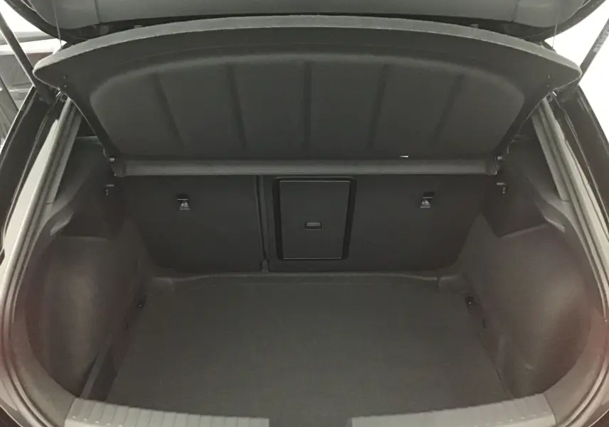 Coffre ouvert vu de l'arrière d'une CUPRA Leon noire 2023, montrant un espace de chargement vide et propre.