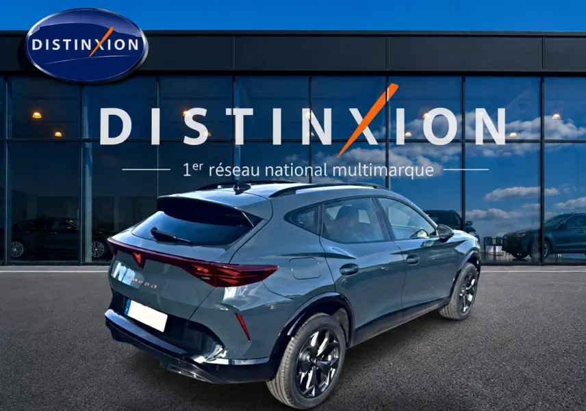 Vue 3/4 arrière droite d'un CUPRA Formentor bleu fjord avec jantes noires devant une vitrine Distinxion.
