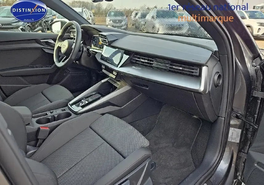 Intérieur avant droit de l'Audi A3 Sportback 45 TFSI e 2024 gris Daytona avec tableau de bord moderne et sièges sport noirs.