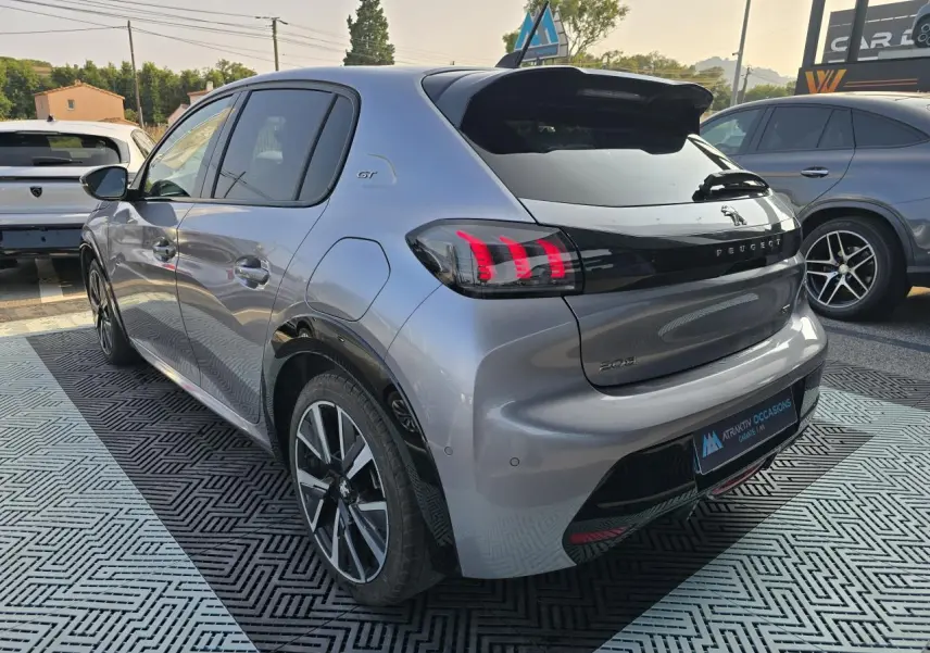 Vue 3/4 arrière droite d'une Peugeot 208 grise 2023 avec toit Black Diamond et jantes alliage 17 pouces Bronx.