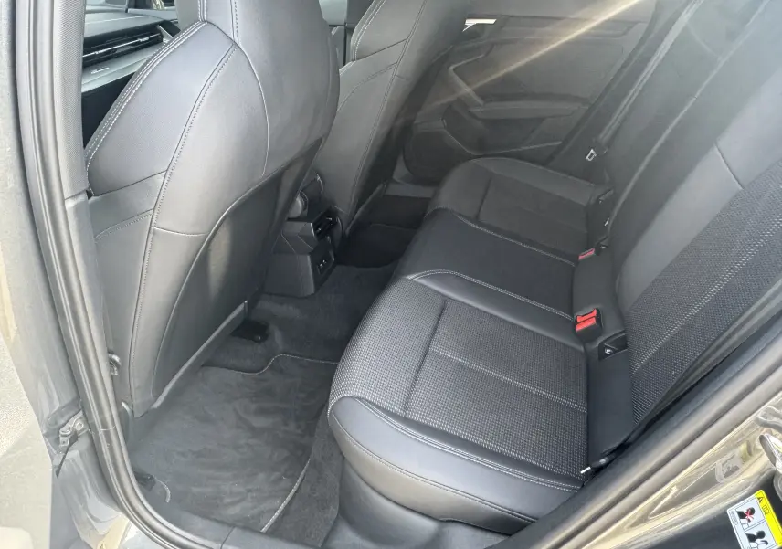 Vue intérieure arrière côté droit de l’Audi A3 Sportback gris 2023, sièges en cuir noir avec surpiqûres blanches.
