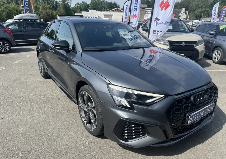 Audi A3 Sportback TDI 2.0 S-Line gris vue 3/4 avant droit, avec calandre noire et jantes alliage distinctives.
