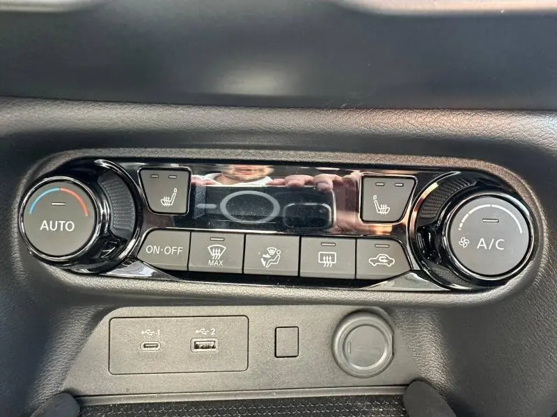 Panneau de commande de climatisation avec boutons chauffants et prises USB dans un Nissan Juke blanc nacré 2025.