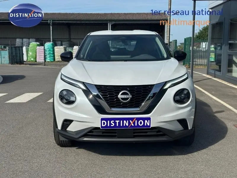 Vue frontale d'un Nissan Juke 2025 blanc nacré avec calandre noire et phares ronds distinctifs.