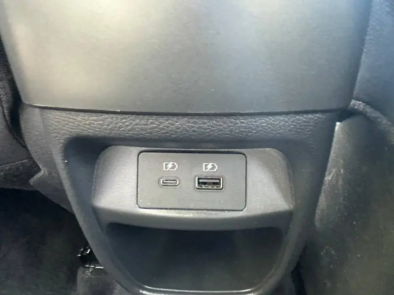 Prise USB-C et USB-A pour recharge, située à l'arrière de la console centrale d'un Nissan Juke blanc nacré 2025.