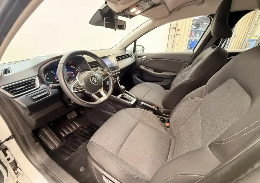Vue intérieure côté conducteur de la Renault Clio Business E-Tech hybride 2022, sièges gris et volant multifonctions cuir synthétique.