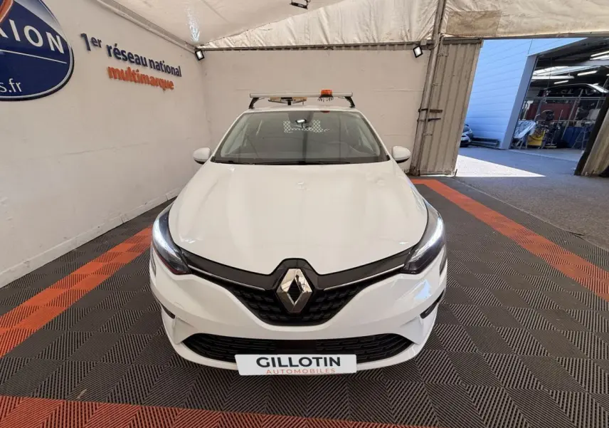 Vue avant d'une Renault Clio Business E-Tech hybride blanche, avec phares LED allumés dans un showroom.