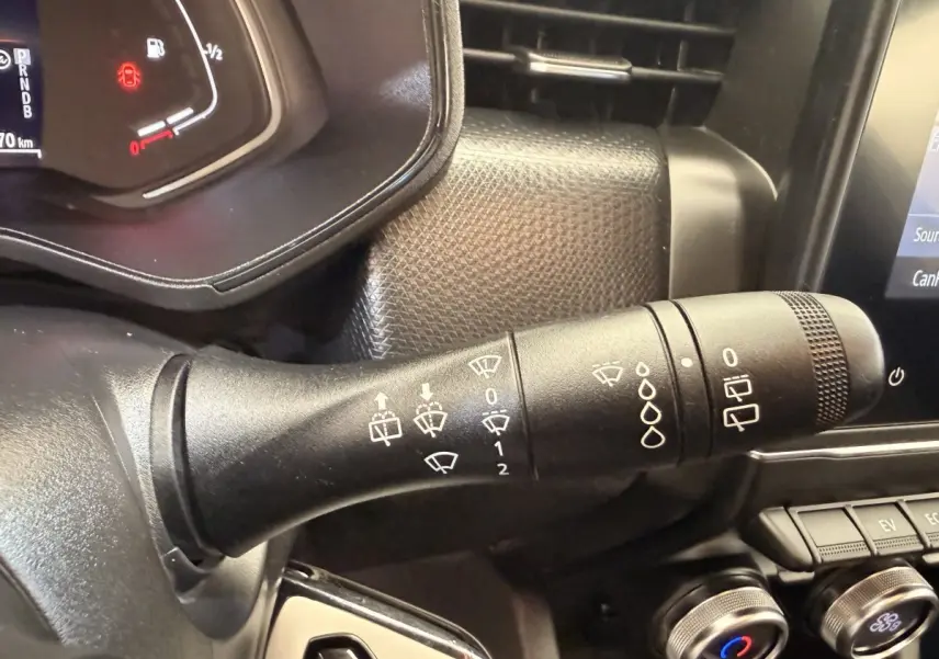 Gros plan sur la manette d’essuie-glace côté gauche du tableau de bord d’une Renault Clio Business E-Tech blanche 2022.