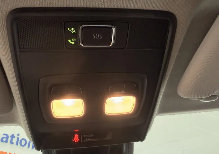 Vue intérieure en plongée sur le plafonnier noir avec éclairage et bouton SOS allumé dans une Renault Clio blanche.