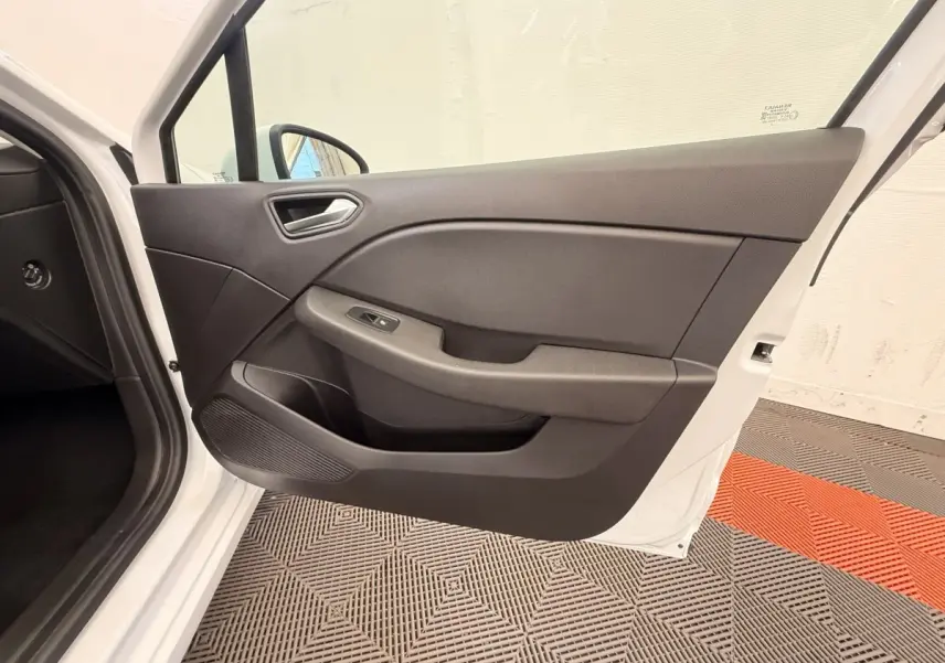 Vue intérieure de la porte avant gauche ouverte d'une Renault Clio Business E-Tech hybride blanche, avec panneau noir et commandes électriques.