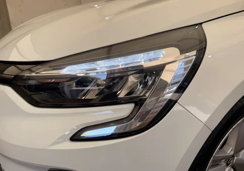 Gros plan sur le phare avant droit LED d'une Renault Clio Business E-Tech hybride blanche de 2022.