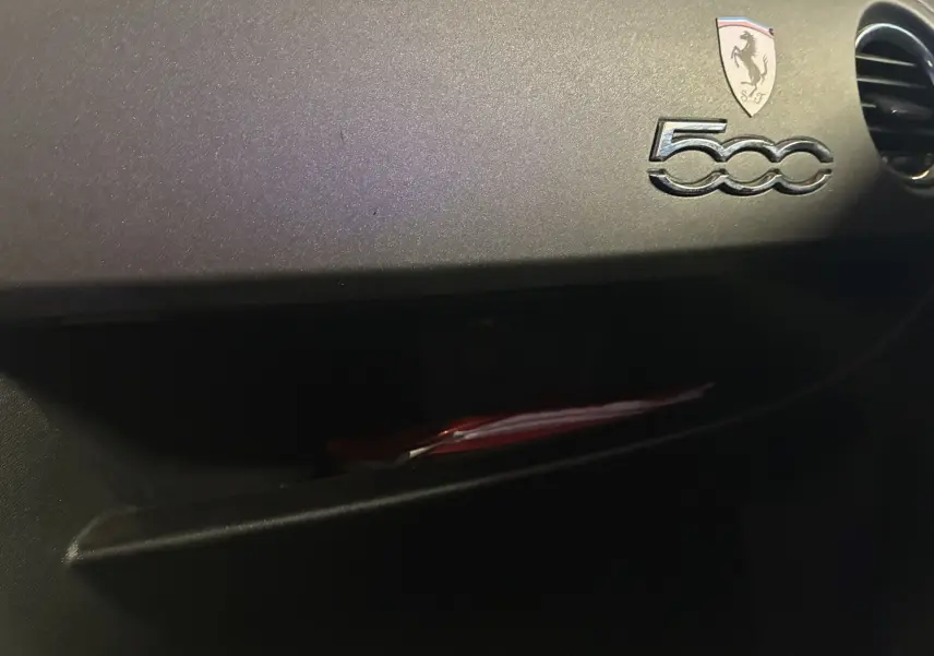 Détail de la planche de bord côté passager de l'Abarth 500 rouge 2016 avec logo 500 et écusson Abarth.