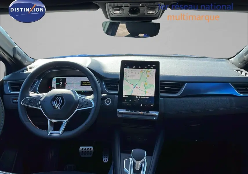 Vue intérieure frontale du tableau de bord du Renault Captur E-Tech hybride 2025 avec écran tactile et volant multifonction noir.