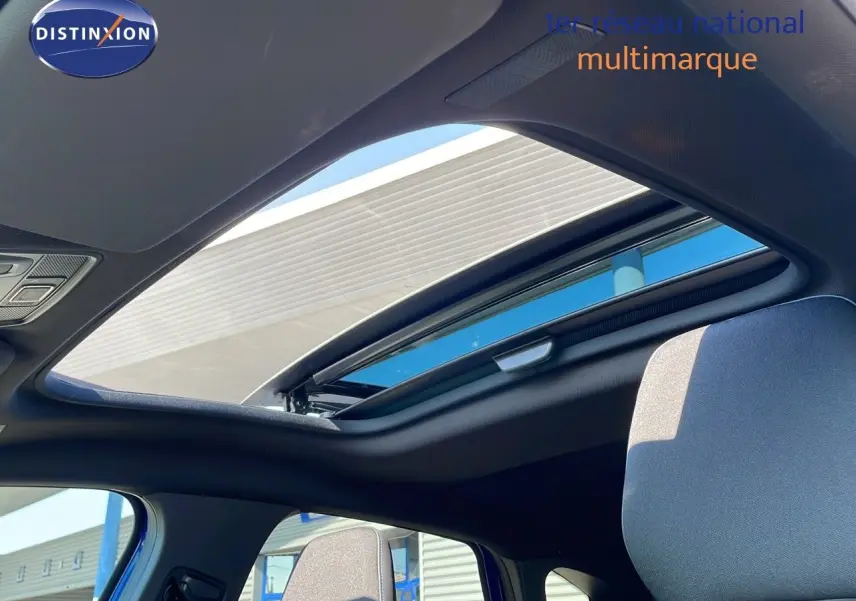 Toit ouvrant panoramique ouvert sur l'intérieur du Renault Captur bleu iron metal avec toit noir, vue côté gauche.