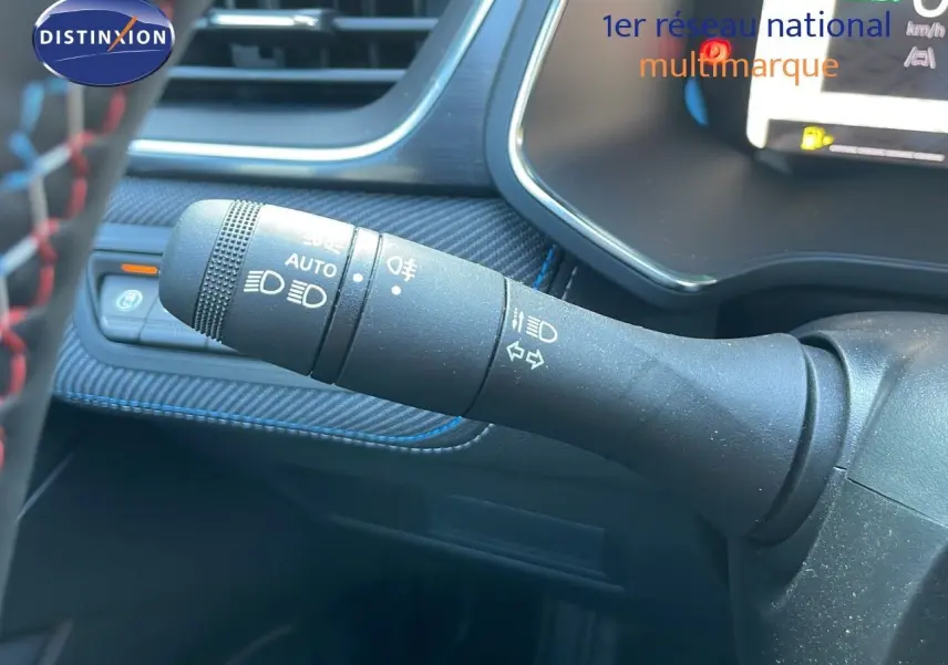 Gros plan sur la commande des feux et clignotants du tableau de bord du Renault Captur E-Tech hybride 2025 bleu iron metal.
