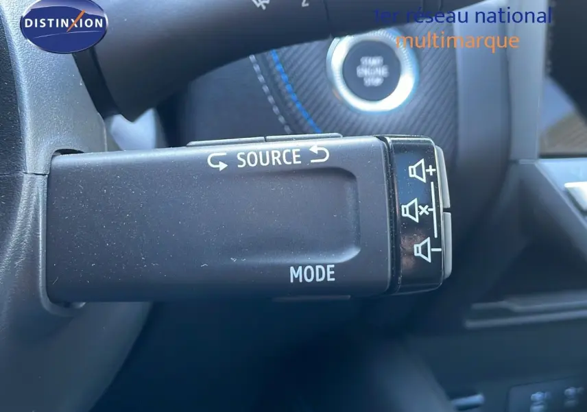 Gros plan sur la commande audio au volant du Renault Captur E-Tech Hybrid 2025 avec détails des boutons et finition noire.