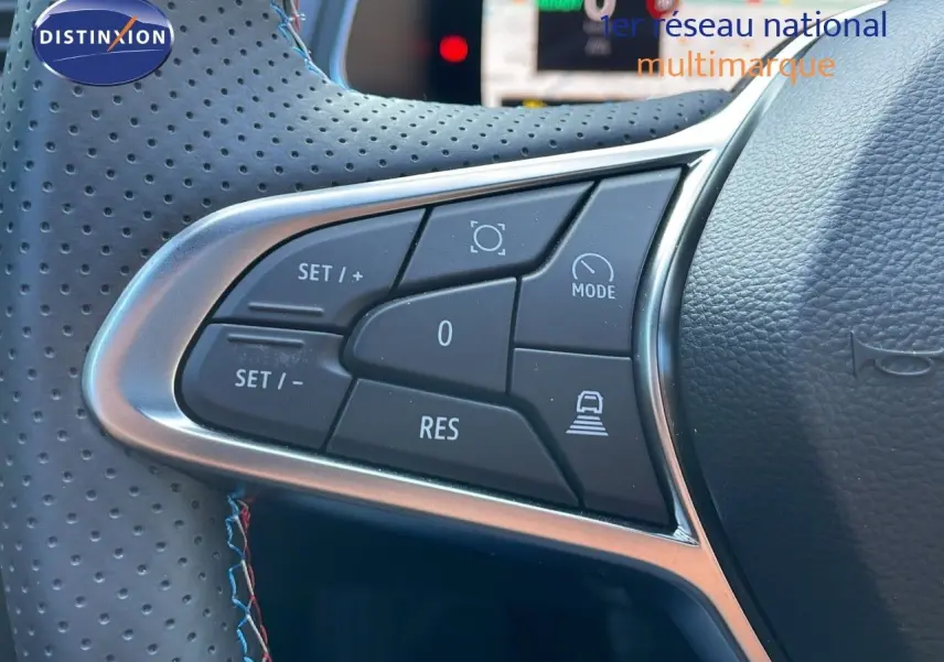 Gros plan sur les commandes de régulateur de vitesse au volant en cuir perforé du Renault Captur E-Tech hybride 2025.