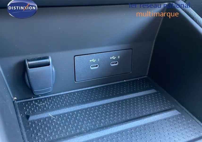 Prise USB double et prise 12V dans le compartiment de rangement avant d'un Renault Captur bleu iron metal toit noir.