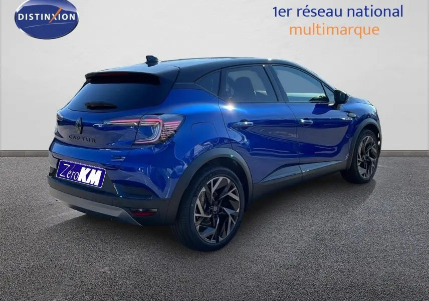 Renault Captur E-Tech hybride bleu Iron Metal avec toit noir, vue 3/4 arrière côté droit sur sol gris.