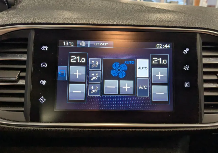 Écran tactile central de la Peugeot 308 noir 2017 affichant les réglages de la climatisation à 21°C en vue frontale.