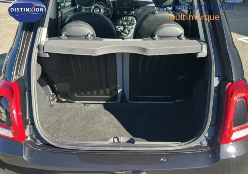 Vue arrière du coffre ouvert d'une FIAT 500 noire série 4, montrant l'intérieur et le tableau de bord.