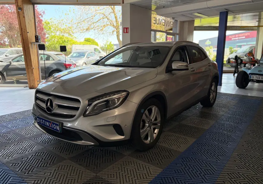 Mercedes GLA 200D Business gris vue 3/4 avant droit dans un showroom avec jantes alliage et calandre chromée.
