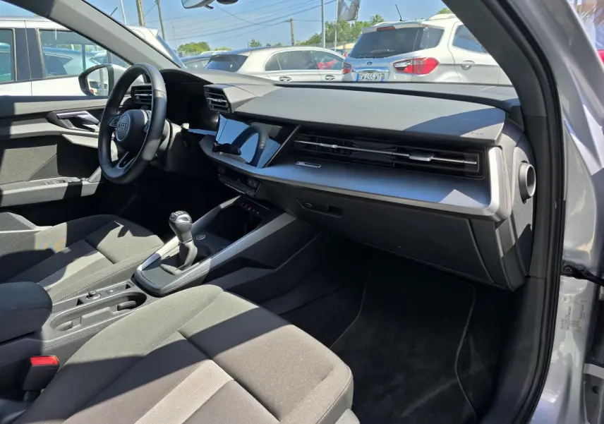 Intérieur de l'Audi A3 Sportback 2022 vu côté passager, tableau de bord moderne et volant cuir noir.