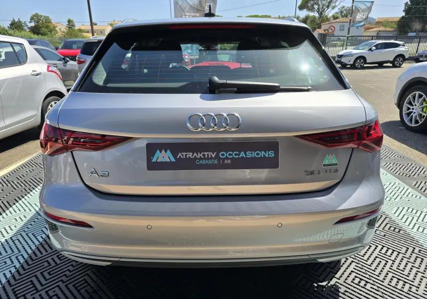 Vue arrière d'une Audi A3 Sportback gris argent fleuret avec feux LED et logo 30 TDI visible au soleil.