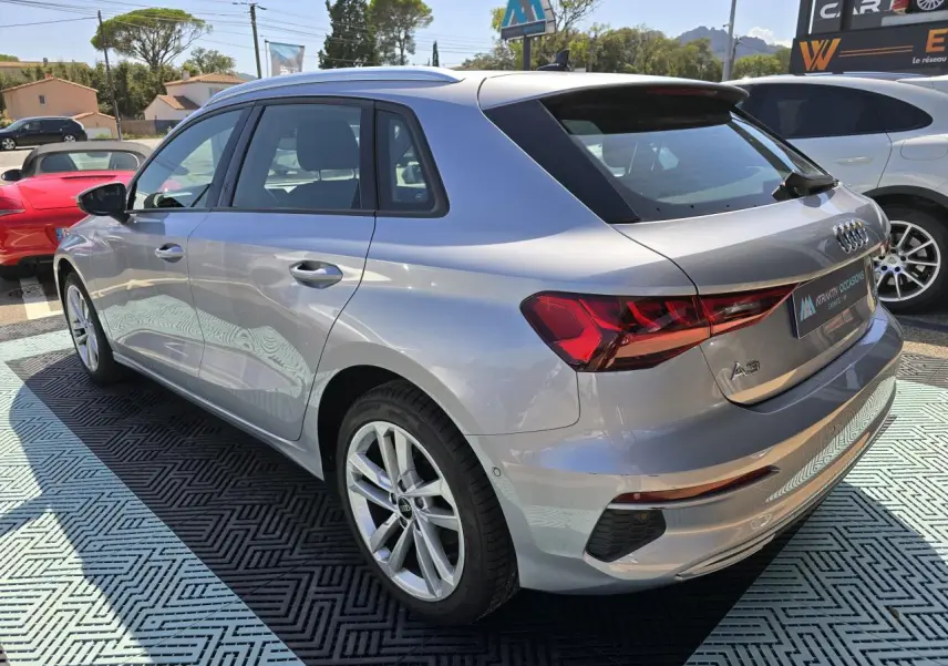 Audi A3 Sportback gris argent fleuret vue 3/4 arrière droit, jantes alliage 17 pouces et feux LED dynamiques.