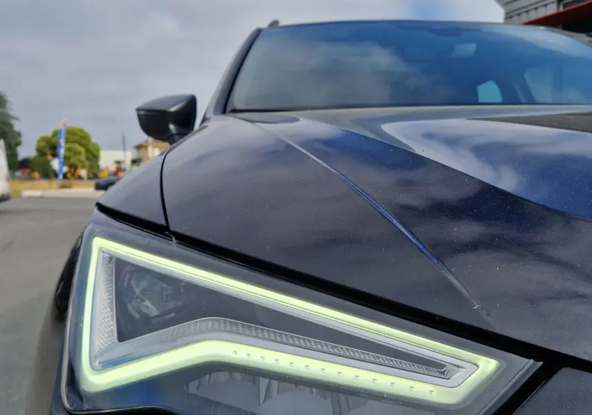 Gros plan sur le phare avant gauche du SEAT Ateca noir 2023, soulignant son design LED distinctif.