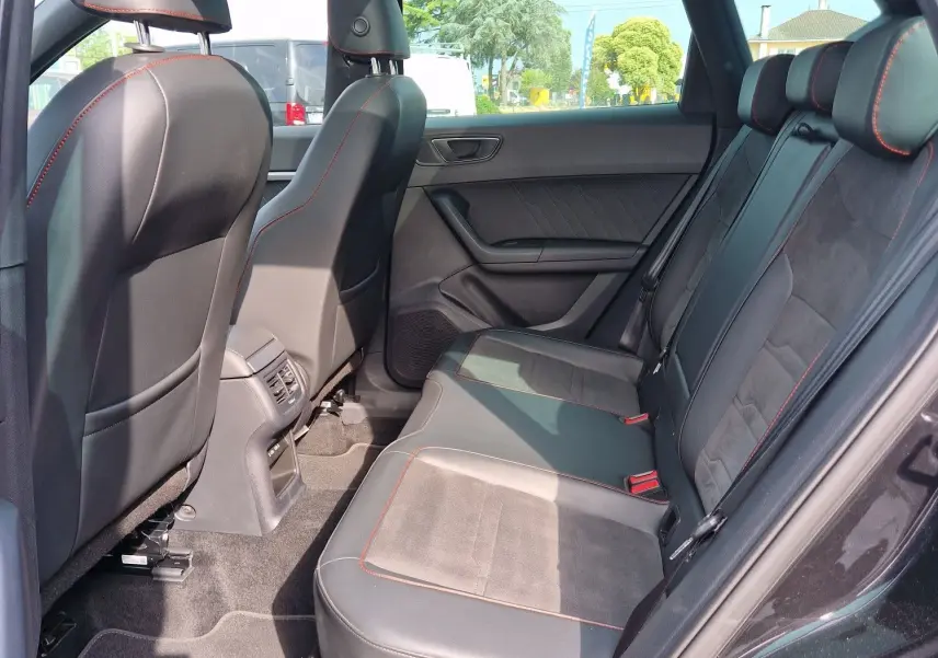 Vue intérieure côté droit des sièges arrière en cuir noir avec surpiqûres rouges et toit panoramique du SEAT Ateca 2.0 TDI 2023.
