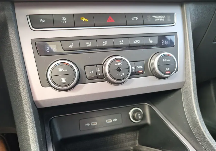 Gros plan sur la console centrale du SEAT Ateca 2023, montrant les commandes de climatisation et les ports USB.