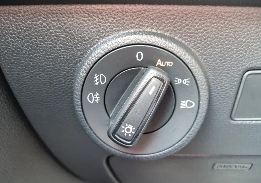 Gros plan sur le sélecteur de phares du tableau de bord noir du SEAT Ateca 2.0 TDI 150 CH DSG7 2023.