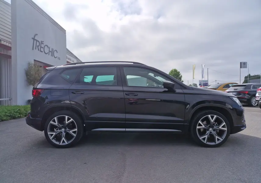 Vue de profil côté gauche d'un SEAT Ateca noir 2023 avec jantes alu 19 pouces, toit panoramique et hayon électrique.
