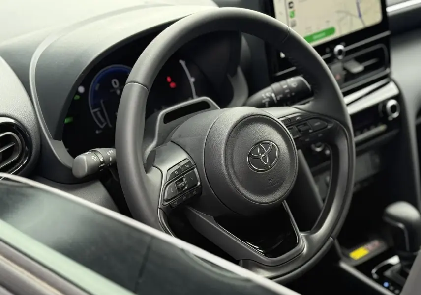 Vue rapprochée du volant en cuir et du tableau de bord numérique de la Toyota Yaris Cross 1.5 Hybrid 116 Design.