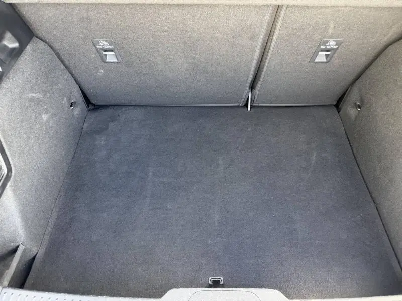 Vue plongeante sur le coffre spacieux et propre de la Ford Focus 1.5 EcoBlue gris lunaire, avec banquette arrière rabattue.