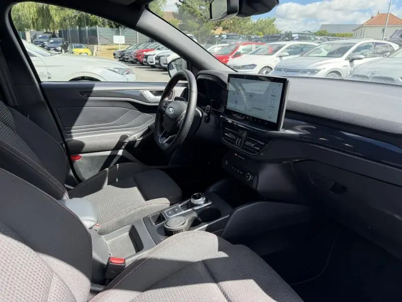 Vue intérieure côté conducteur de la Ford Focus 2025 gris lunaire, avec écran tactile central et volant cuir multifonction.
