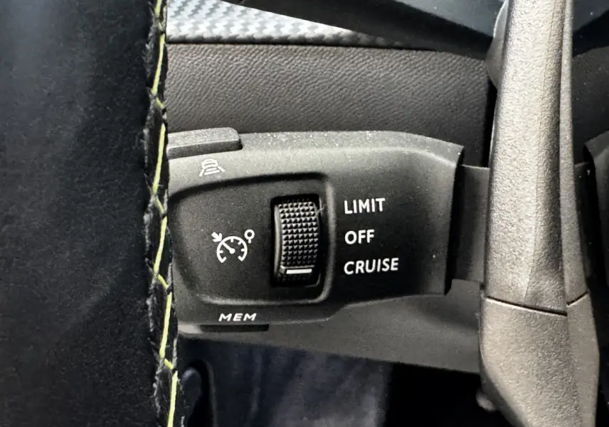 Gros plan sur la commande de régulateur de vitesse du volant cuir du Peugeot E-2008 GT Pack noir électrique.