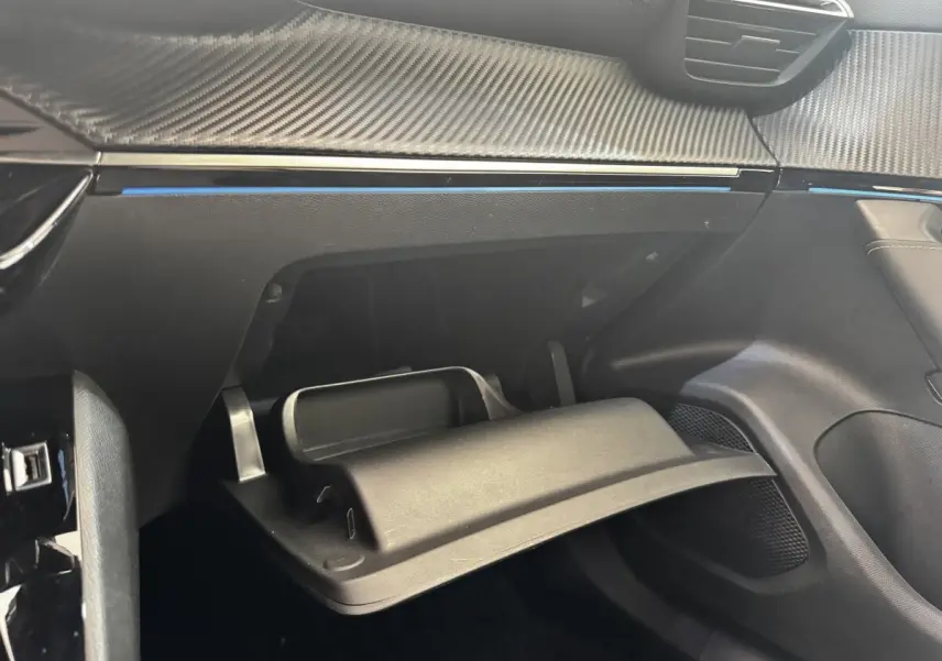 Vue intérieure côté passager du Peugeot E-2008 GT Pack électrique 2021, montrant la boîte à gants ouverte et le tableau de bord noir.