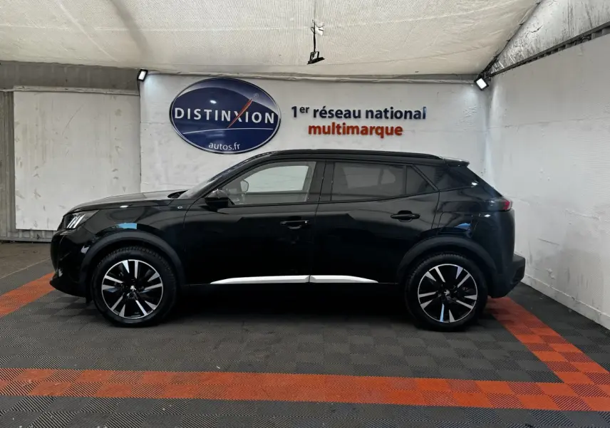 Peugeot E-2008 électrique GT Pack noir vu de profil côté gauche, avec jantes noires et détails chromés.