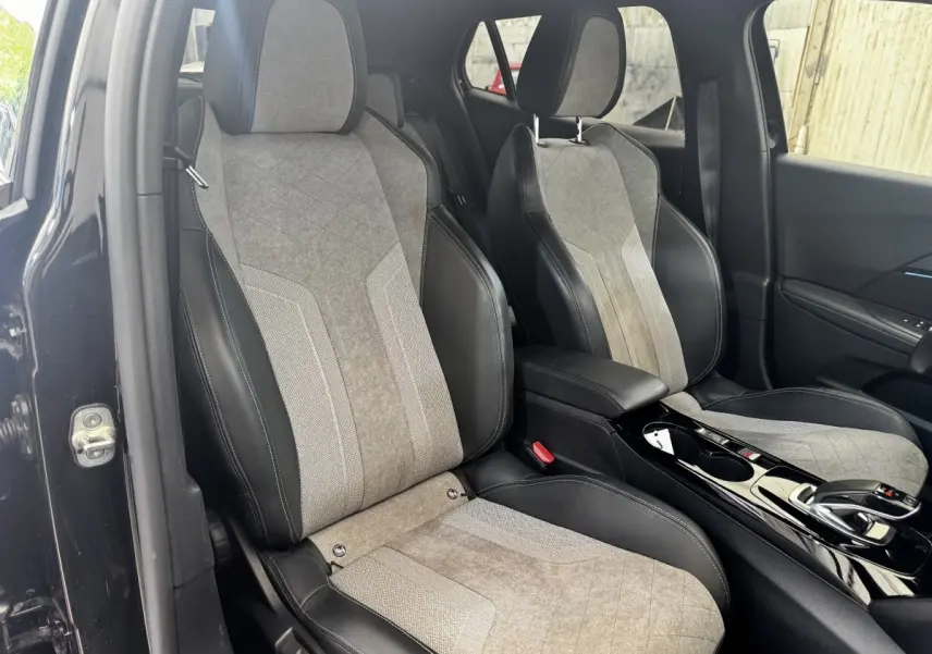 Vue intérieure des sièges avant en tissu gris et cuir noir du Peugeot E-2008 électrique GT Pack 2021, côté droit.
