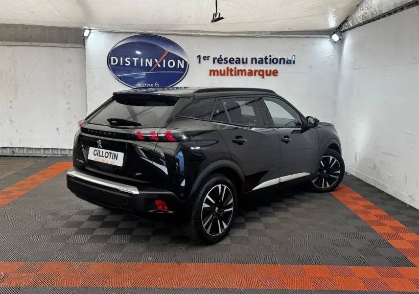 Peugeot E-2008 électrique GT Pack noir, vue 3/4 arrière droit, jantes alliage et feux arrière LED distinctifs.
