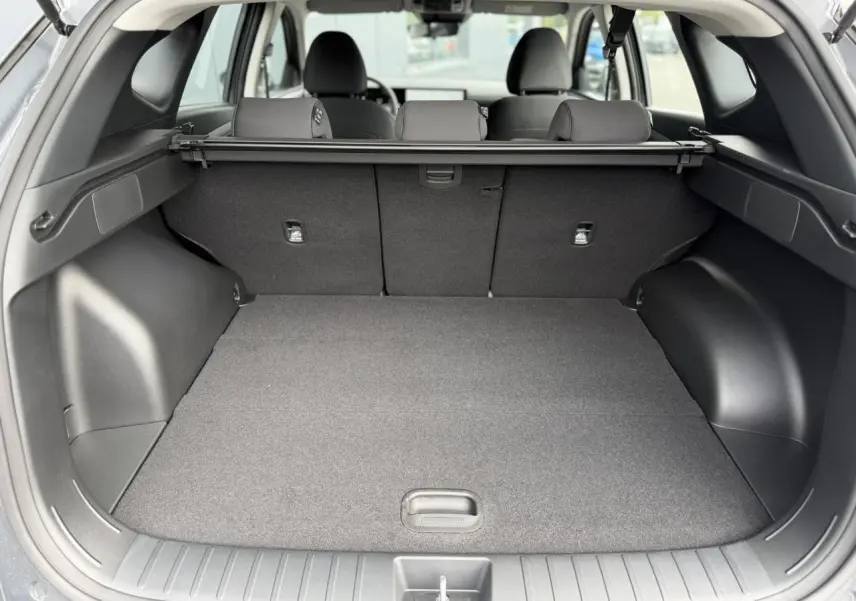 Coffre ouvert vu de l'arrière du Hyundai Tucson Ecotronic Gray 2026, montrant l'espace de chargement et la plage arrière.